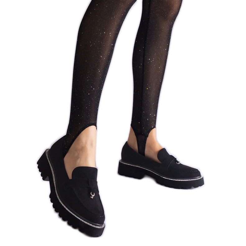 Mocasinele negre ale pielii din piele de căprioară cu un ornament negru Mocasinele negre ale pielii din piele de căprioară cu un ornament negru