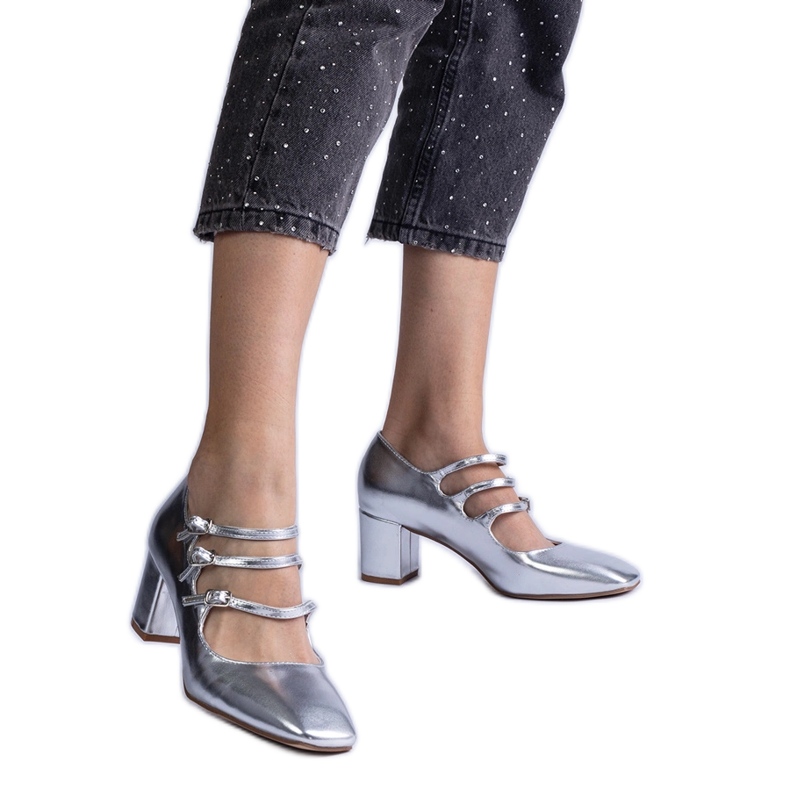 Pompe de argint pe un post cu catarame metalice decorative